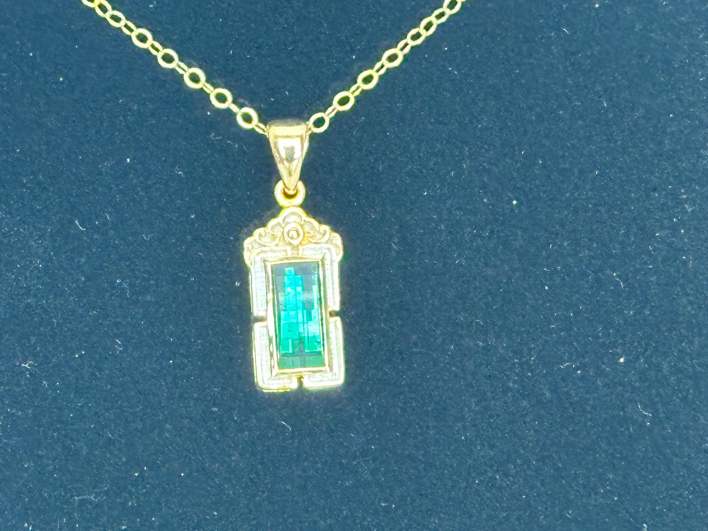 A blue/green Tourmaline mounted in a hand crafted 14K Gold pendant